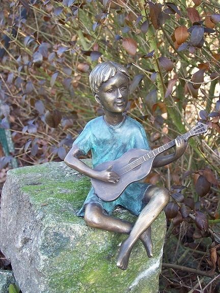 Der Junge Benjamin spielt Gitarre als Bronzeskulptur