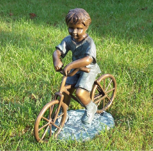 Kleiner Junge auf seinem Fahrrad als Bronzeskulptur